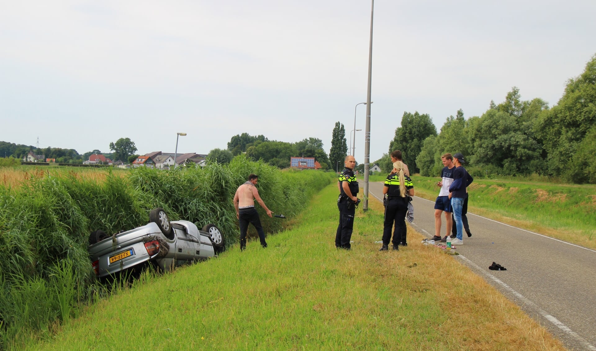 De auto raakte door onbekende oorzaak in de sloot naast de weg (foto: Olav Spa).