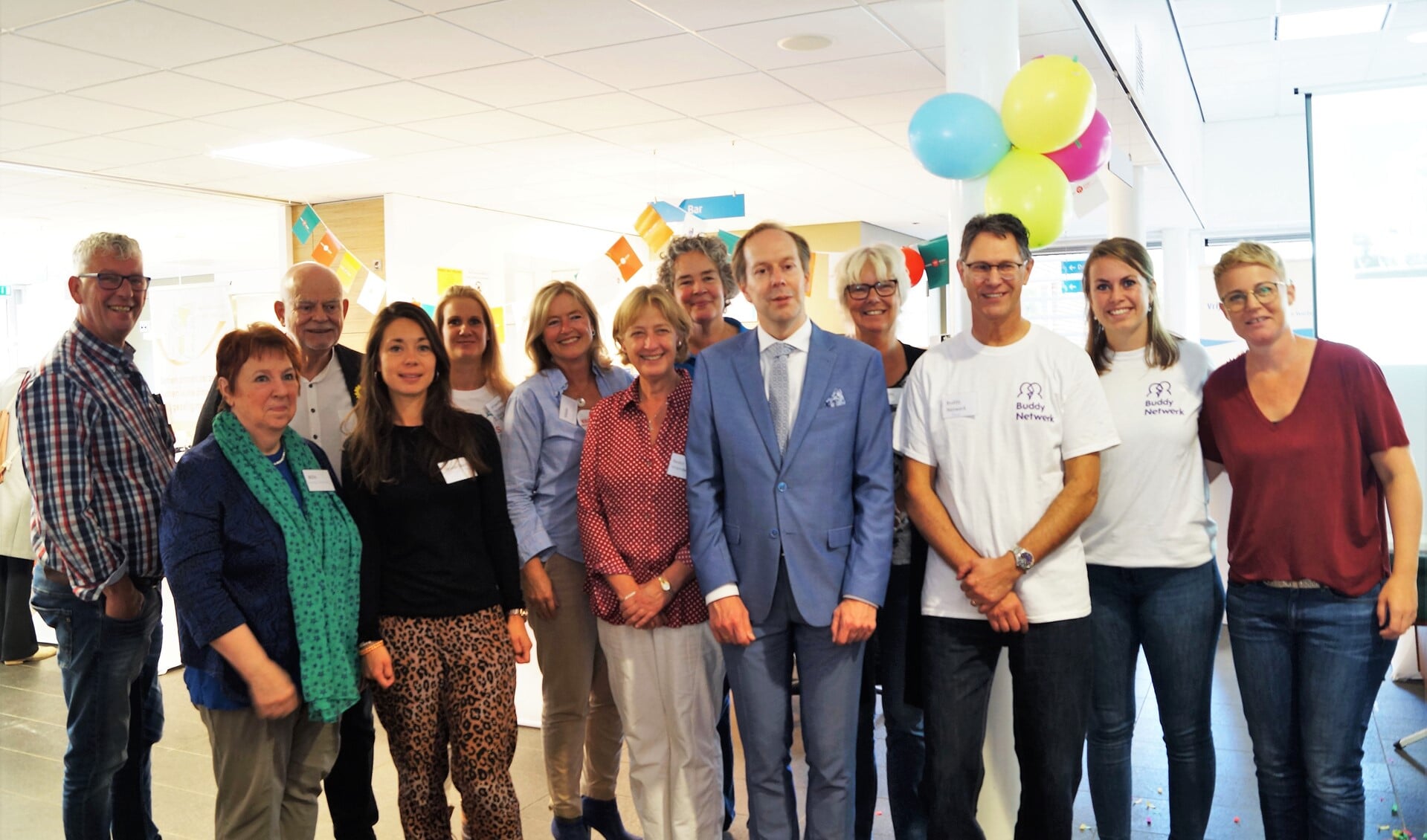 Wethouder Rouwendal omringd door de negen organisaties achter zorgvoorelkaarLV.vrijwilligerspunt.nl (foto: Iloisa Fortes).