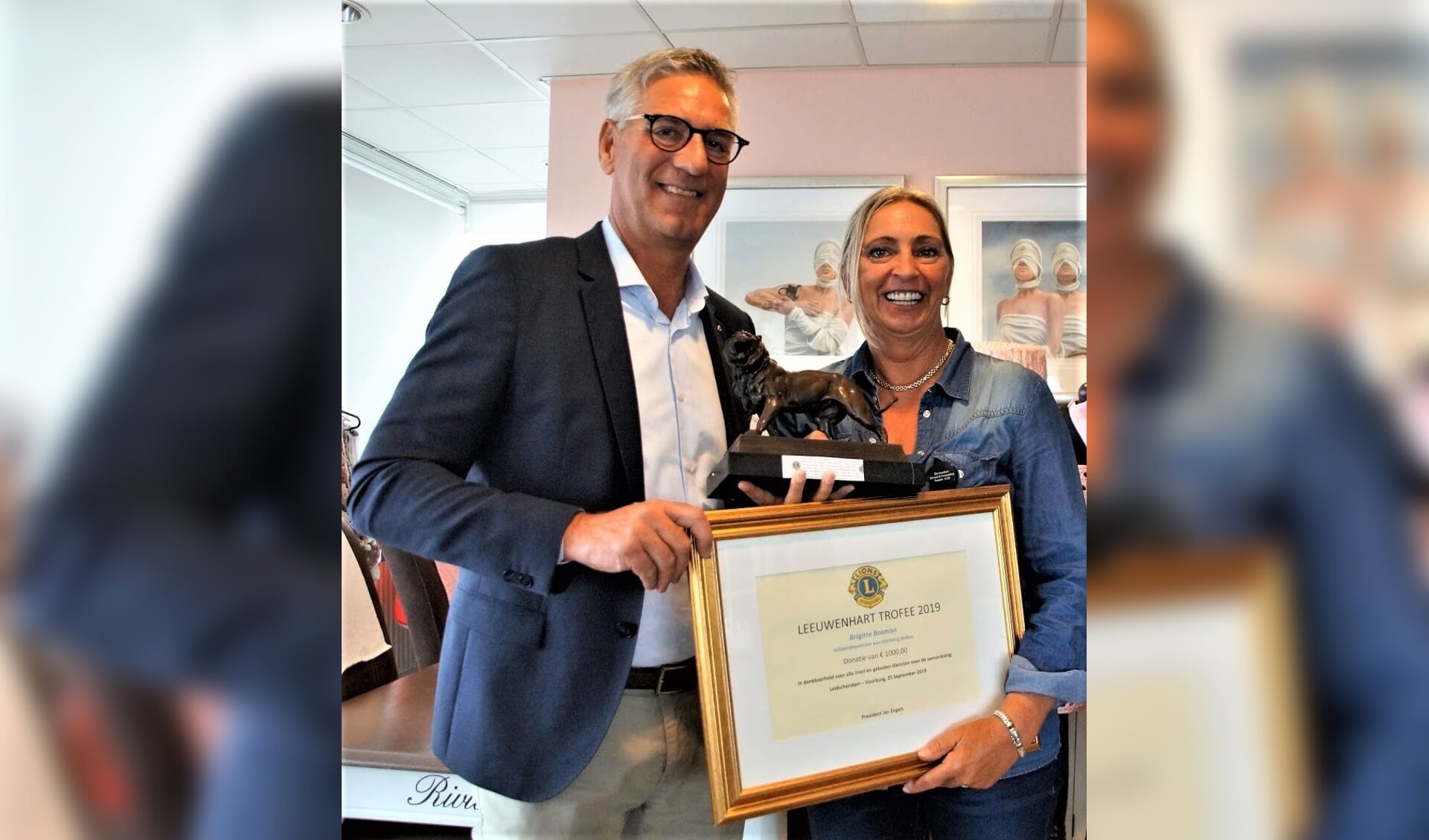 Jan Engels van de Lionsclub reikt de Leeuwenhart Trofee uit aan Brigitte Bosman, oprichtster en initiatiefneemster van de stichting Bribos.