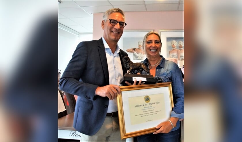 Jan Engels van de Lionsclub reikt de Leeuwenhart Trofee uit aan Brigitte Bosman, oprichtster en initiatiefneemster van de stichting Bribos.