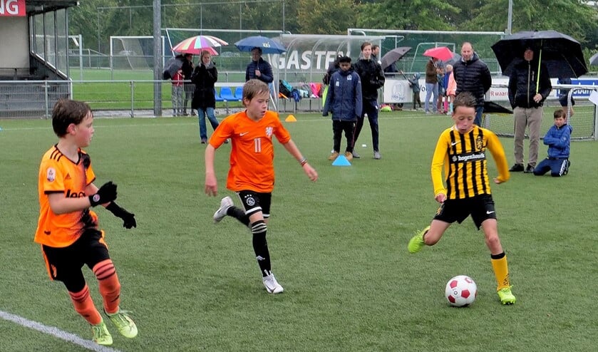 Het 4 tegen 4 toernooi in volle gang maar een paraplu was voor de toeschouwers geen overbodige luxe (foto: Ot Douwes).