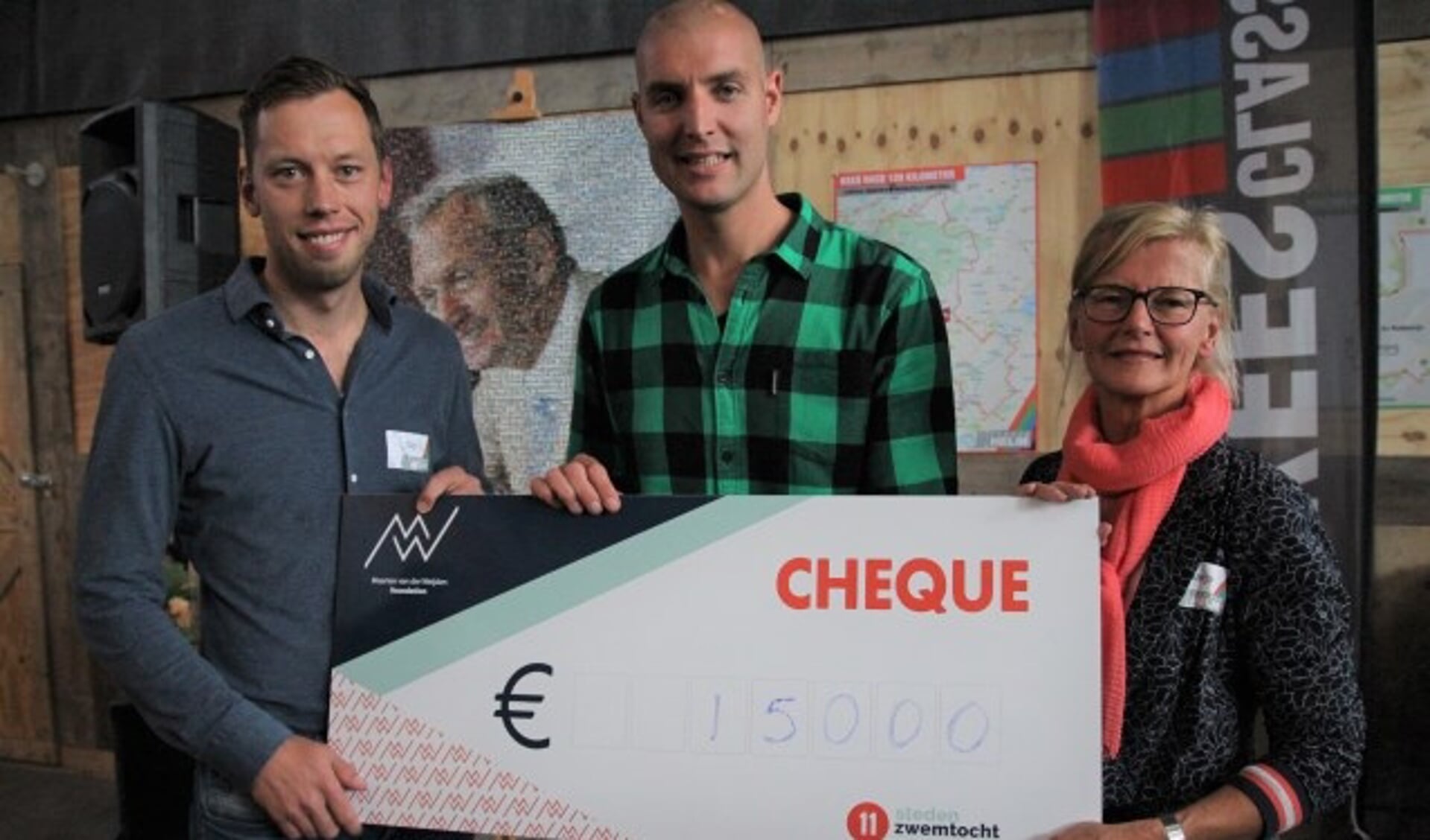 Marja en Gijs van der Helm overhandigden een cheque met 15.000 euro aan Maarten van der Weijden, die dit jaar als eerste mens op aarde de Friese Elfstedentocht helemaal zwom. 