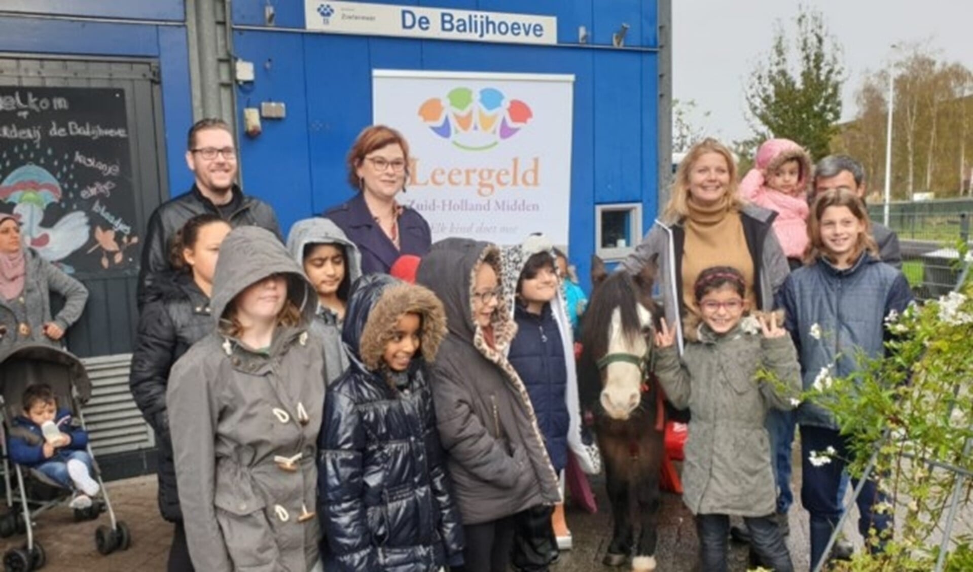 Wethouder Groeneveld samen met enkele kinderen van het project. 