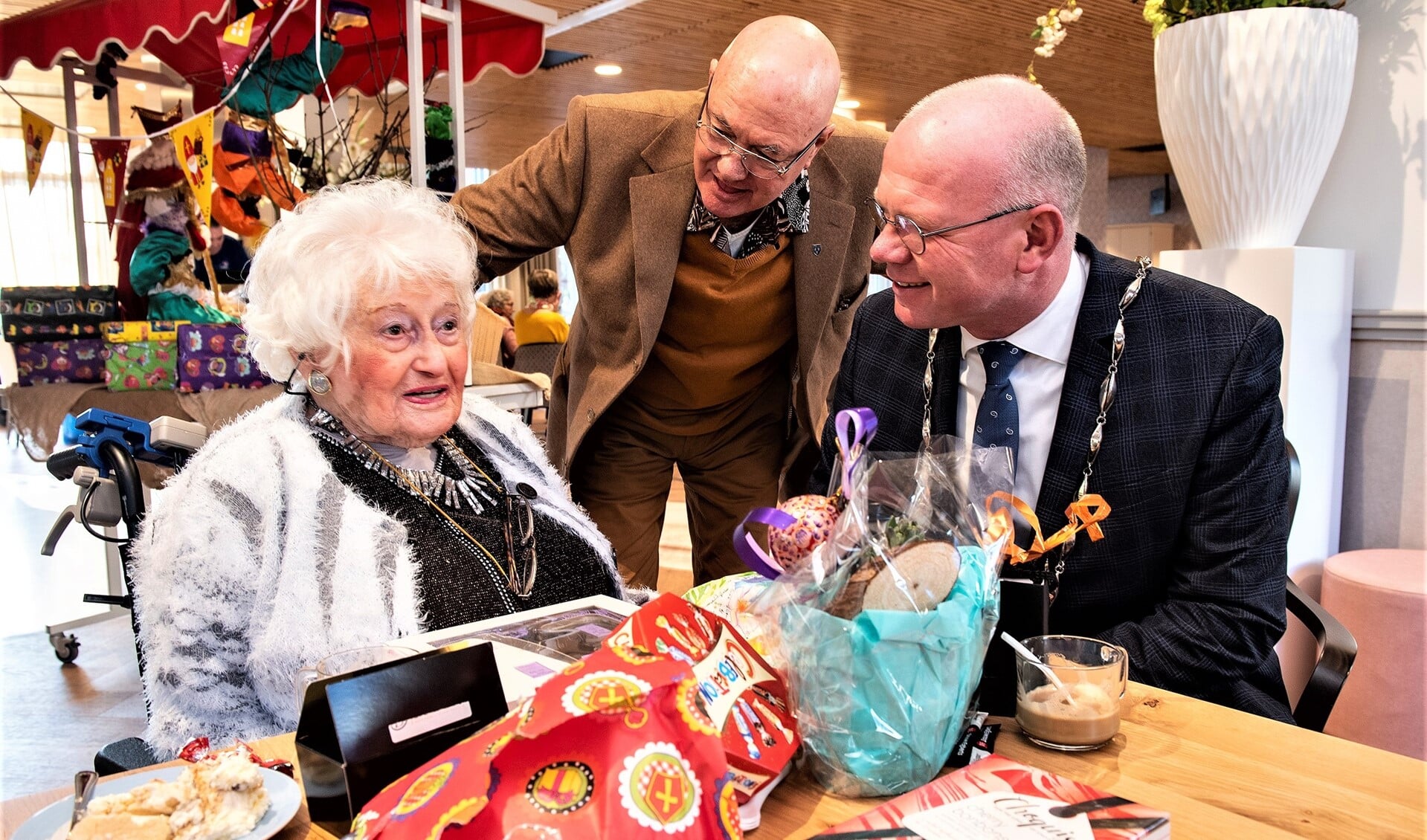 De 106-jarige mevrouw Van Ham in gesprek met burgemeester Tigelaar. Zoon Hendrik luistert aandachtig toe (foto: Michel Groen).