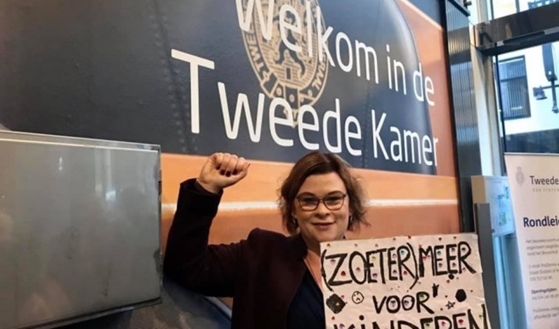 Wethouder Jakobien Groeneveld met haar protestbord dat ze bij binnenkomst moest inleveren van de beveiliging. Foto: Privécollectie