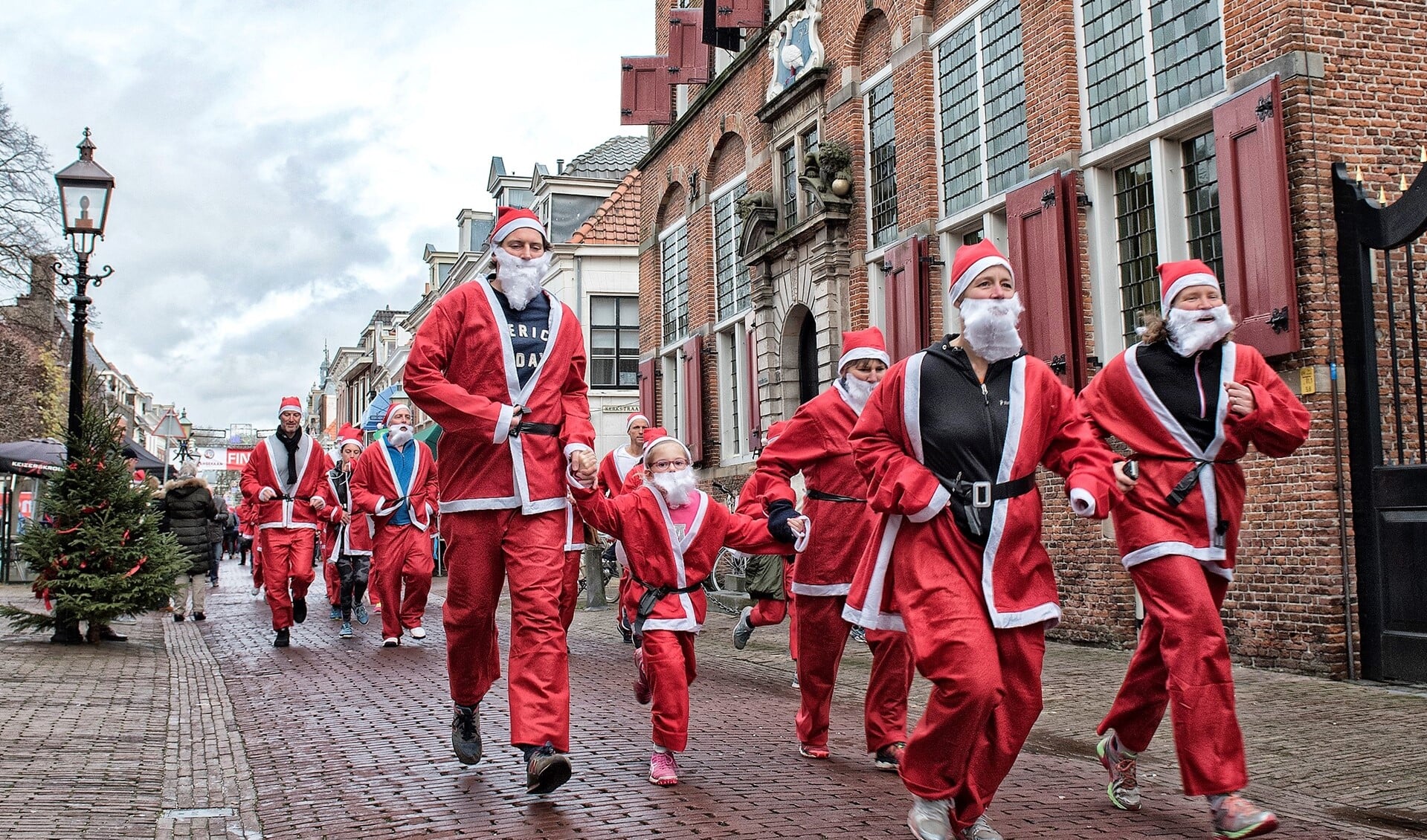 Kinderen en volwassenen rennen als kerstmannen door het Huygenskwartier (archieffoto Michel Groen).