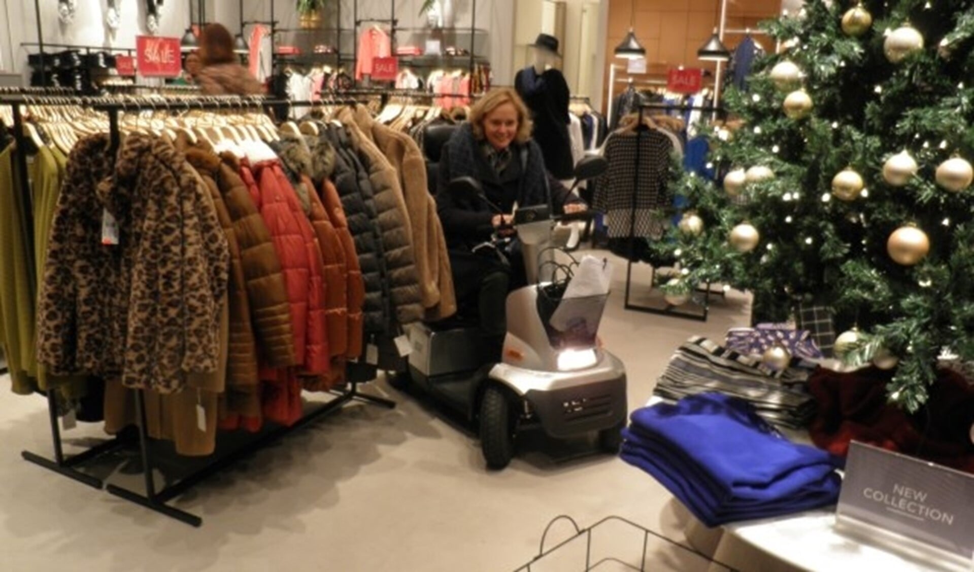 Wethouder Ingeborg ter Laak ervaart hoe het is met een scootmobiel naar kleding voor de feestdagen te zoeken. Foto Kees van Rongen