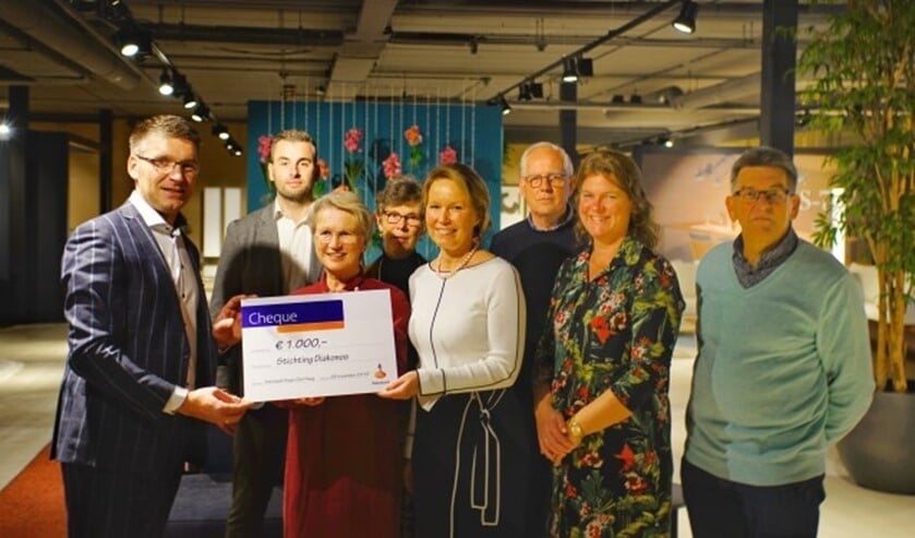Corné van Waay overhandigd de cheque van € 1000,- aan Diákonos. Foto: Robbert Roos