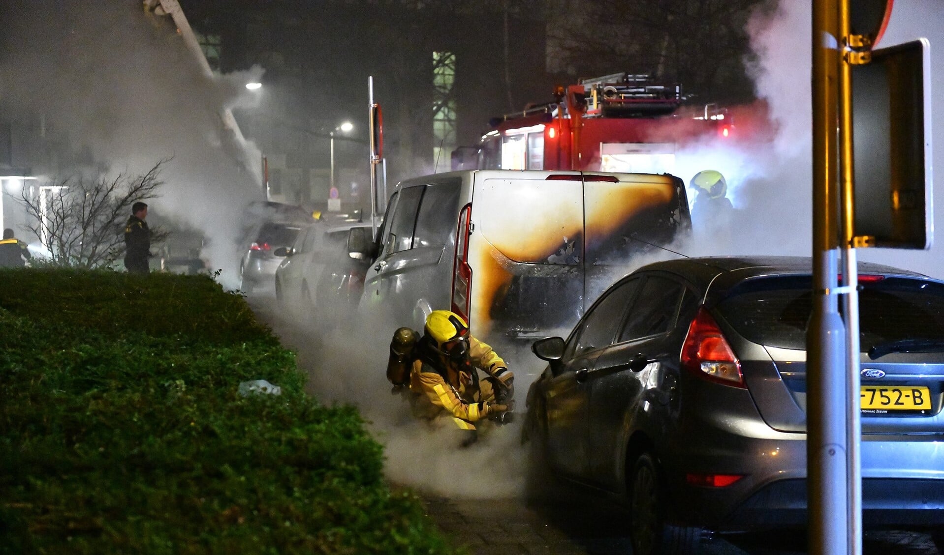 De brandweer druk bezig om de autobranden in de Van Leeuwenstraat te blussen (foto Regio15).
