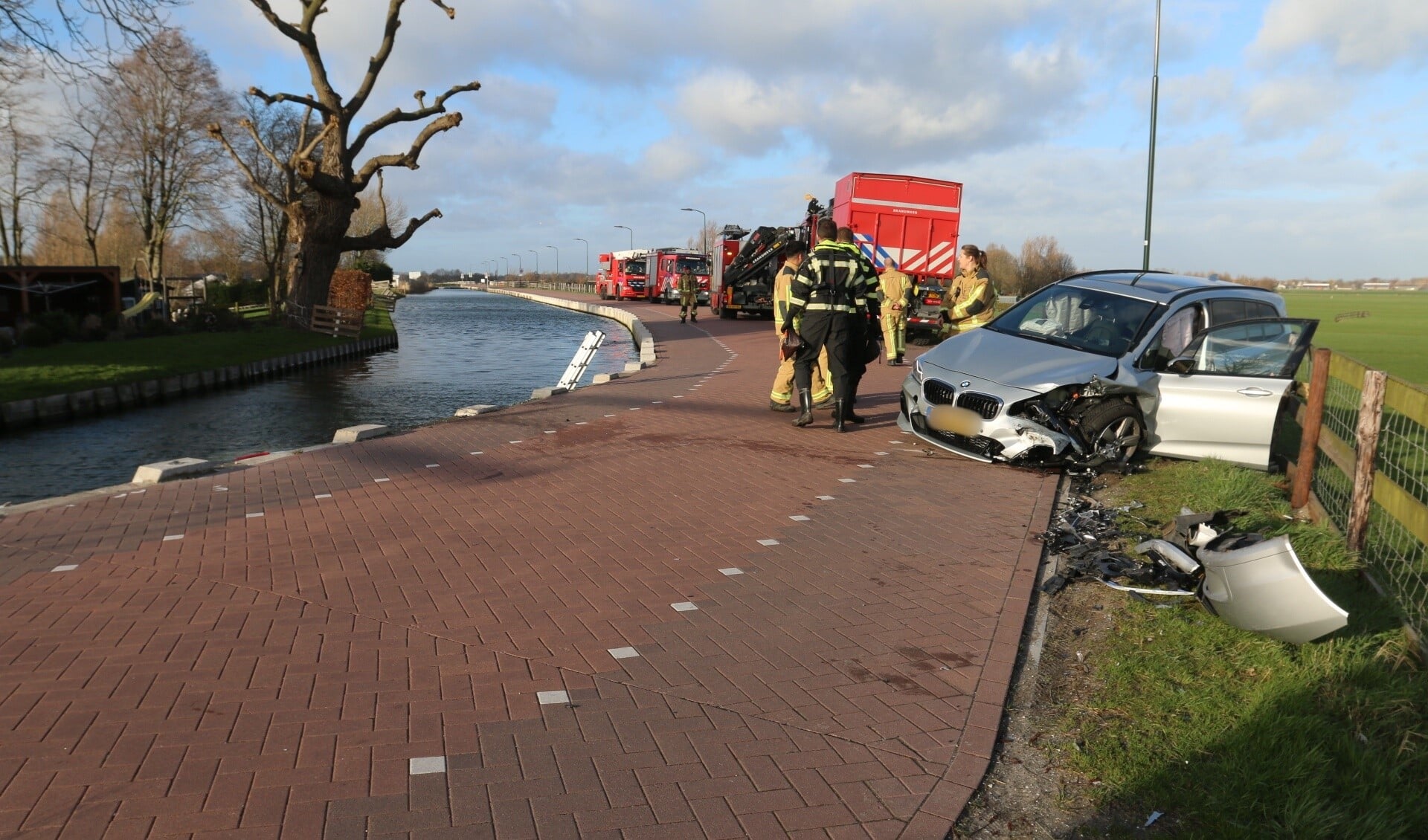 De schade aan zowel het voertuig op de kant als de auto in het water is groot (foto: Ruben van Essen).