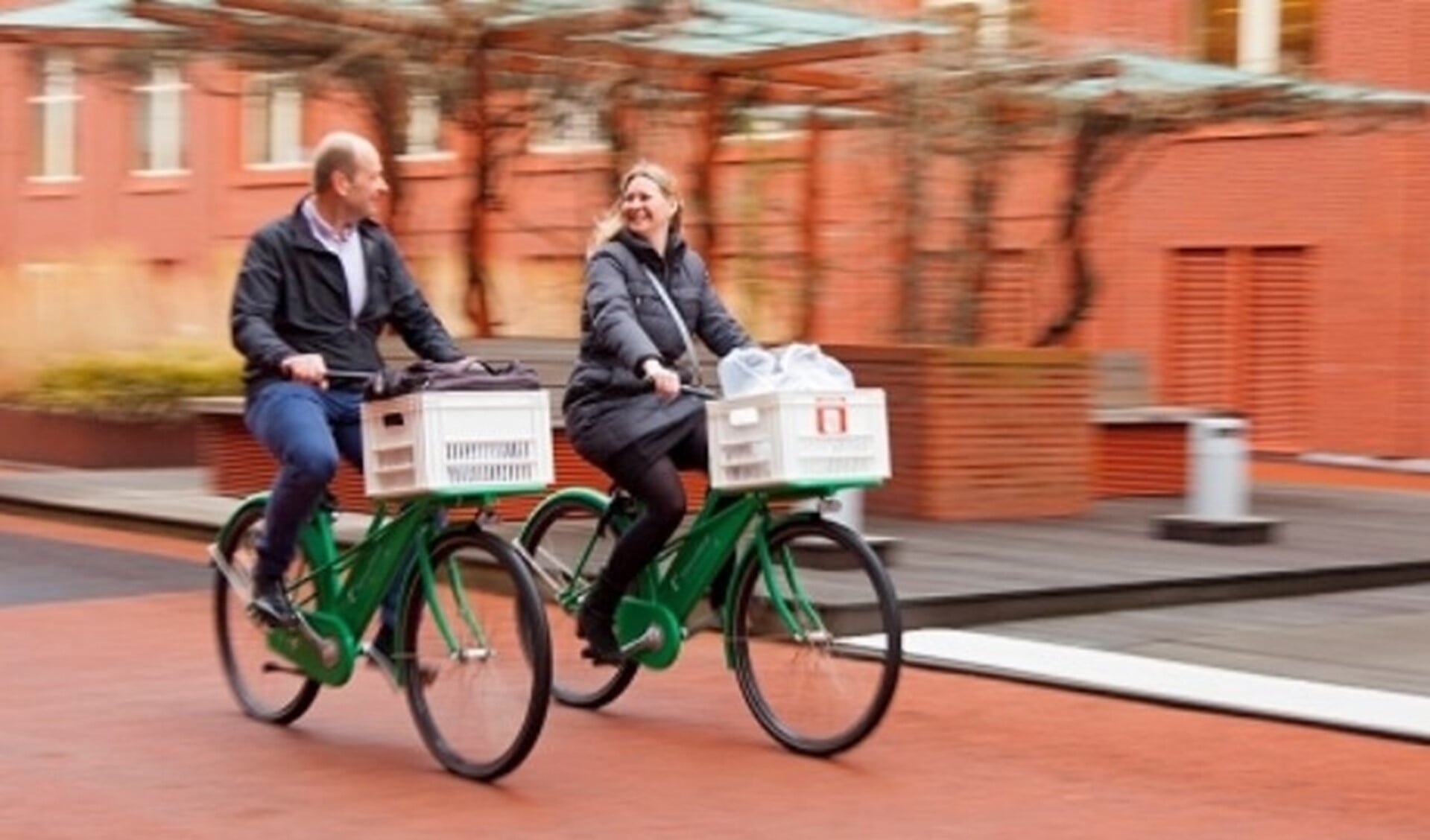 Twee Klaverblad-medewerkers nemen de fiets naar een gastles in de buurt