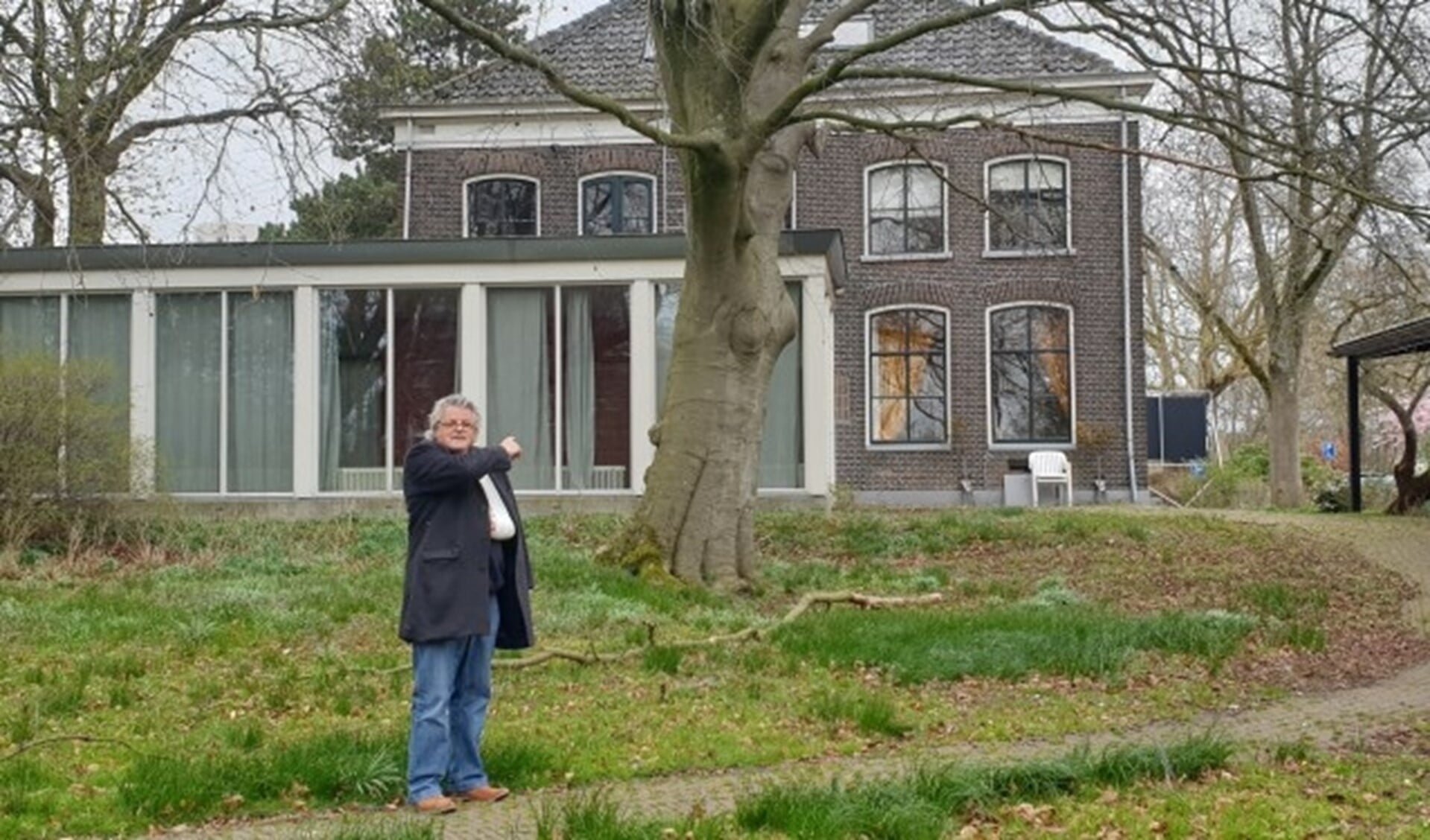 Wim Blansjaar op de plek waar de tuinpaviljoen-appartementen moeten komen. Karakteristieke bomen zoals deze boom blijven in dit plan staan. Foto: Robbert Roos