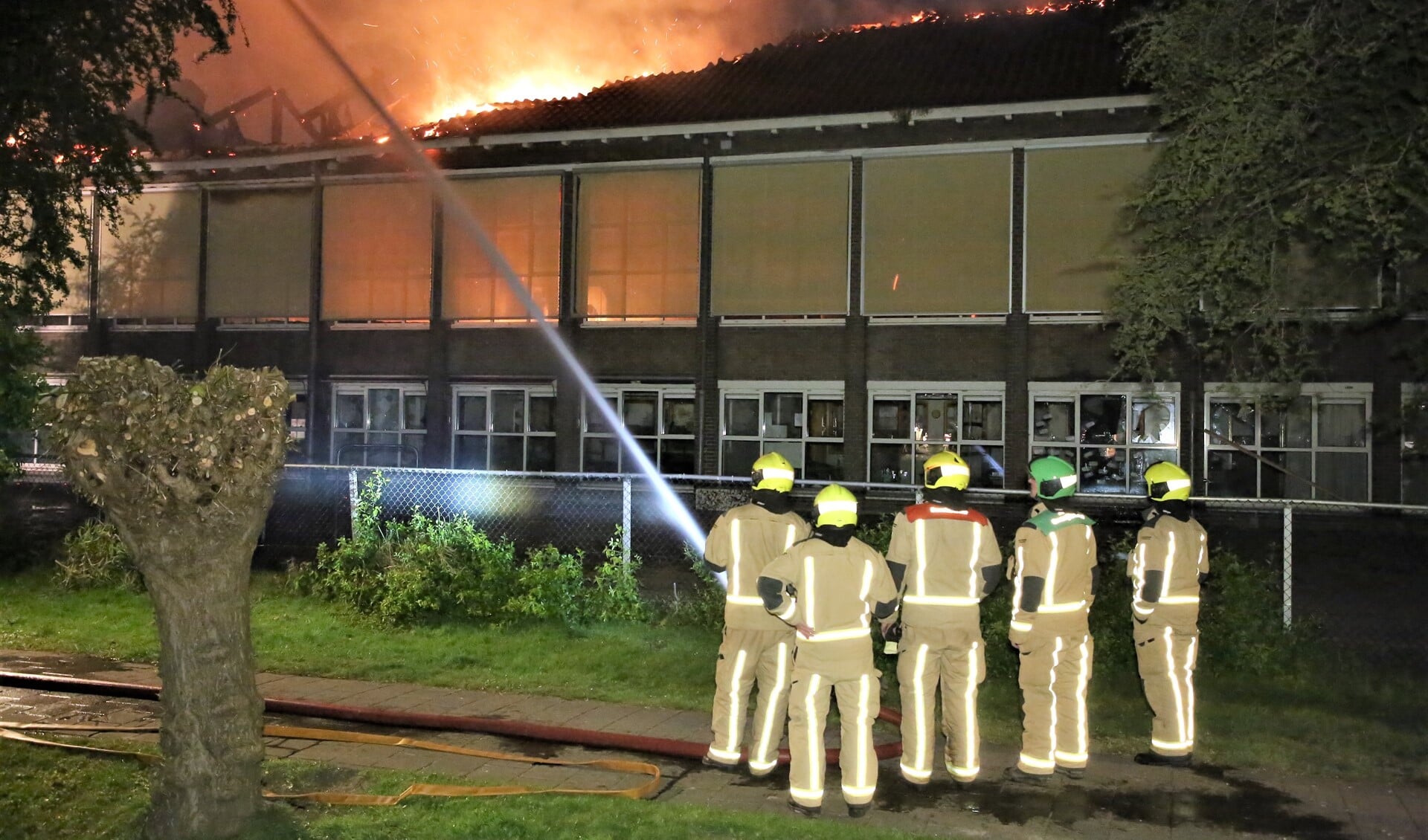 Het vuur sloeg al snel door het dak van de Maerten van de Veldeschool, waarna het te gevaarlijk werd om het pand te betreden en de school als verloren werd beschouwd (foto: Regio15).