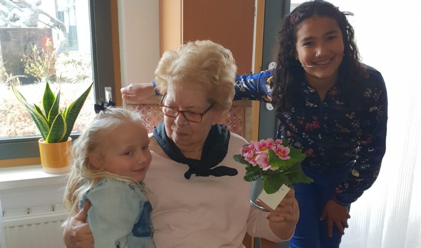 Jade (6 jaar) en Nasira (11 jaar) brengen voorjaarsplantjes naar ouderen in woonzorgcentrum Vivaldi Zoetermeer. Foto: pr