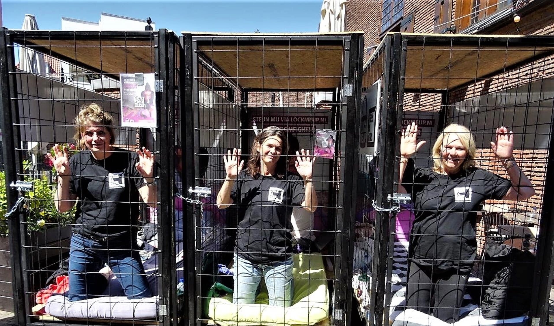 De dames die zich voor de actie 'Lock me Up – Free a Girl' lieten opsluiten in kleine hokjes (foto: Ap de Heus).