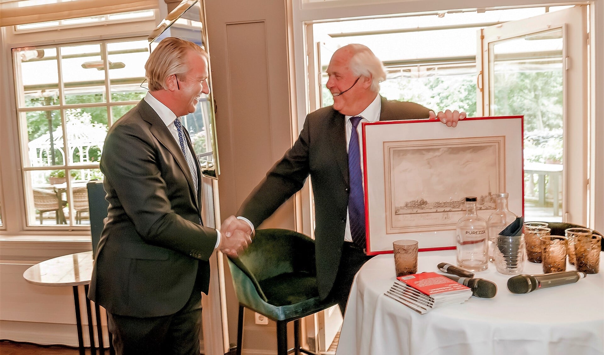 Oprichter Wim van Kampen overhandigt aan zijn opvolger Wim Nieuwenburg de ets die Van Kampen zelf ontving toen hij zo'n 40 jaar geleden werd beëdigd als taxateur-makelaar (foto: Fotozoom!).