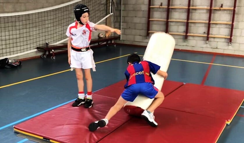 Daniel Avink helpt zijn vader Lucas Avink bij den rugbyclinic op BSO De Vliethorst (foto: pr VRC).