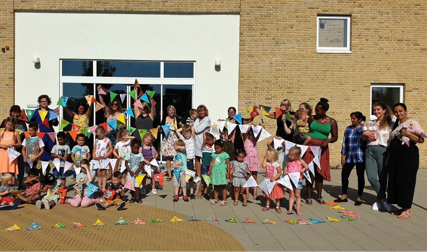 De kinderen zijn trots op hun mooi versierde vlaggetjes van de feestslinger. Foto: pr