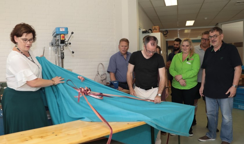Wethouder Jakobien Groeneveld onthult een van de door de houtwerkplaats van Piëzo opgeknapte meubelen. Foto: Jan van Es