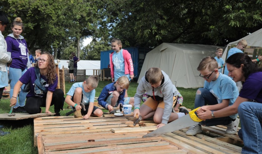 Door op oude pallets te hameren of te zagen wordt een compleet houten dorp in elkaar gezet. Foto: Jan van Es