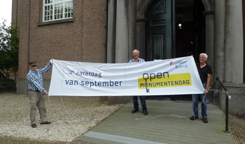 Vrijwilligers van Open Monumentendag met vlag voor de Oude Kerk. Plekken van Plezier staan centraal op 14 september. Foto: Ton Vermeulen