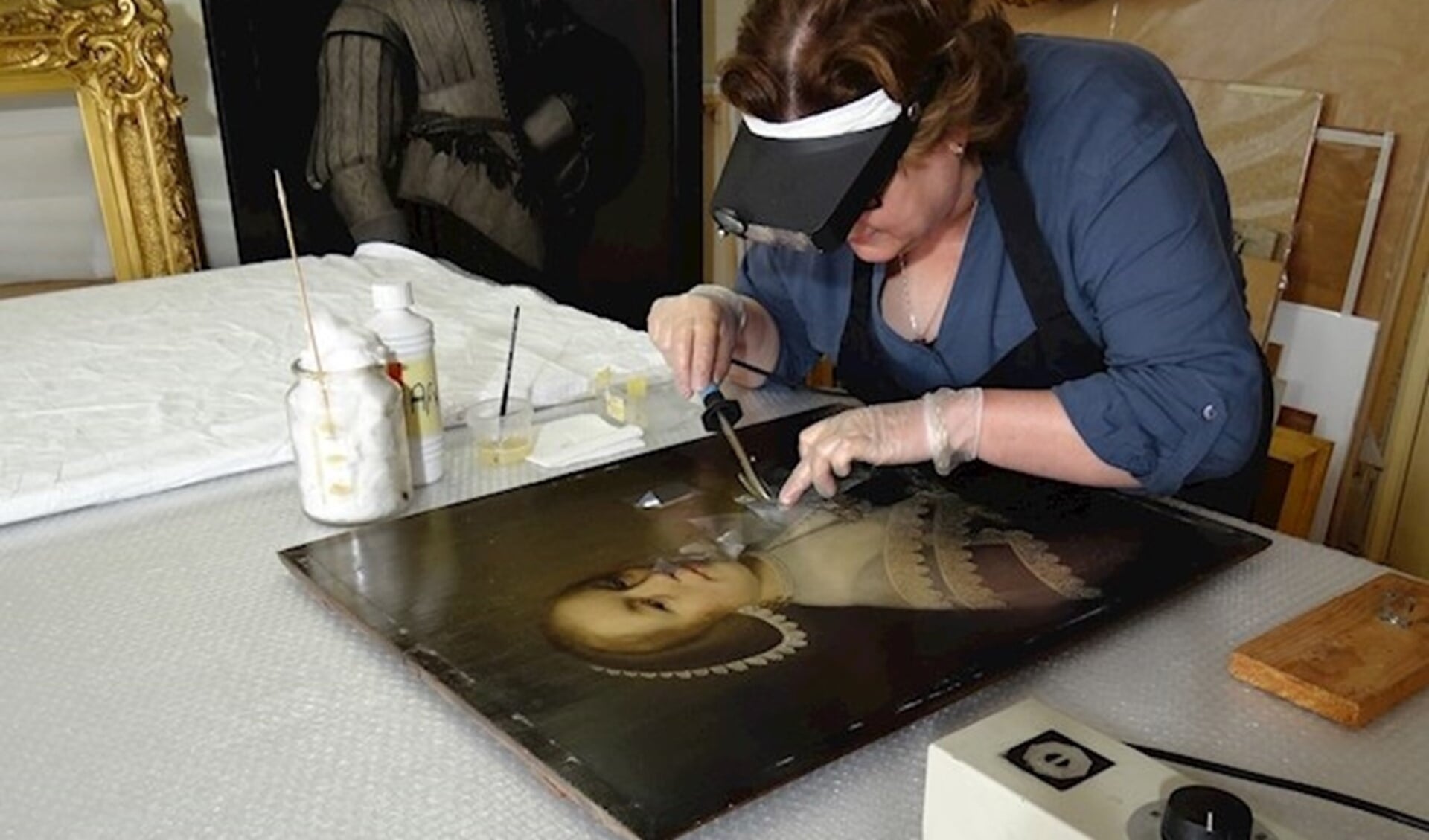 Pauline Marchand aan het werk met een van de schilderijen uit Kasteel Duivenvoorde (pr St. Duivenvoorde).