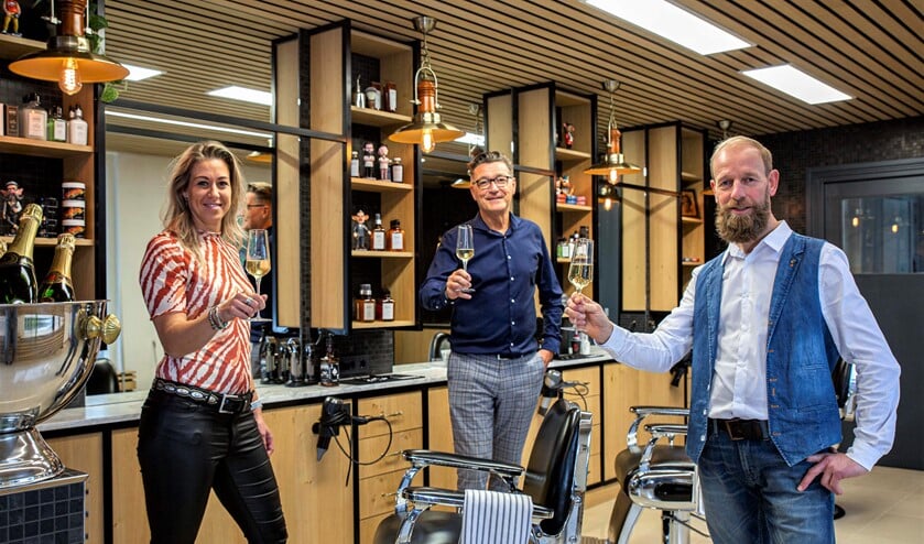 <p>Marco Rimmelzwaan (l.) en de andere teamleden proosten op de heropening van de zaak (foto: Harry Scholtes). </p>