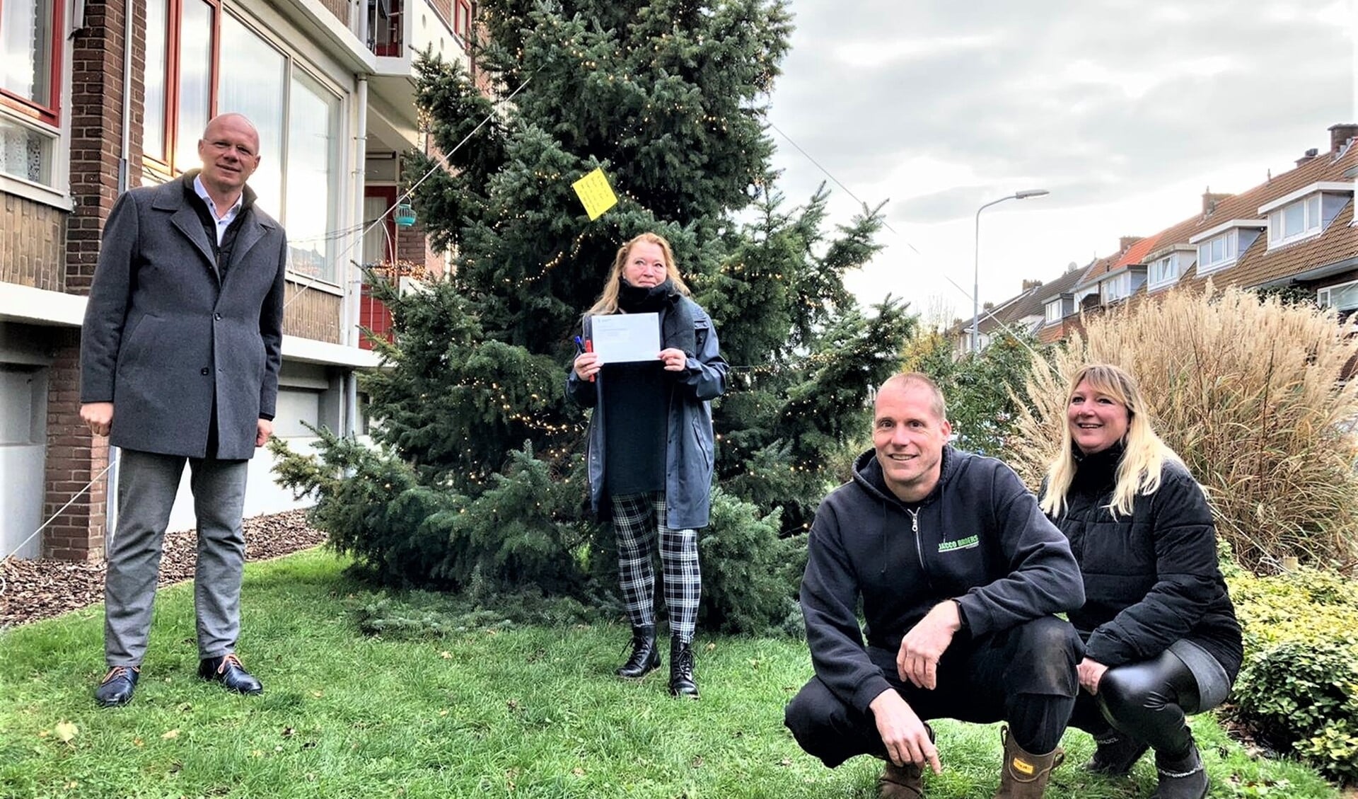 Burgemeester Klaas Tigealaar kwam hoogstpersoonlijk langs op de Von Geusaustraat om de vergunning te overhandigen en zelf ook een kerstwens in de boom te hangen (foto: gemeente LV).