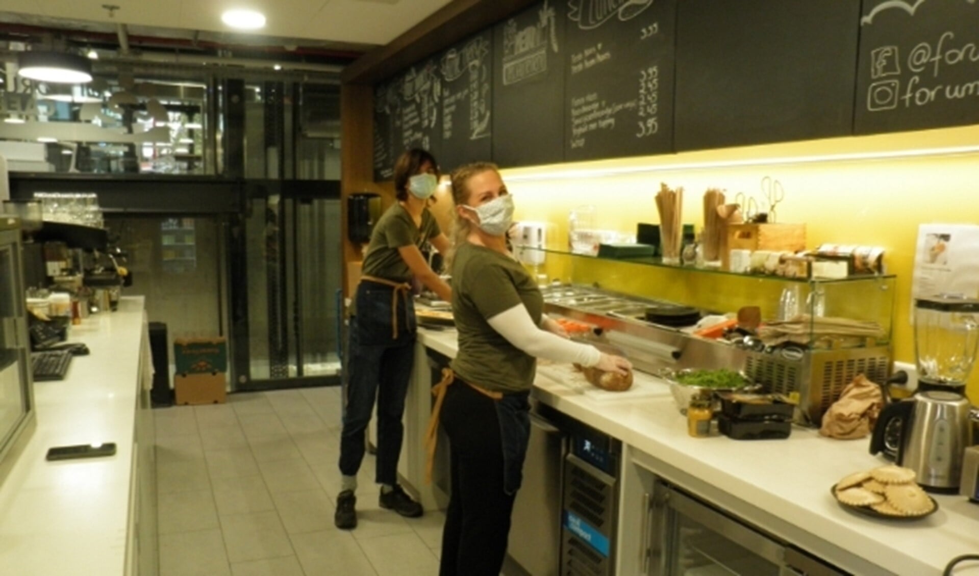 Anita van der Voort op de voorgrond bereidt met een medewerker de lunch in het Forumcafé. Foto Kees van Rongen