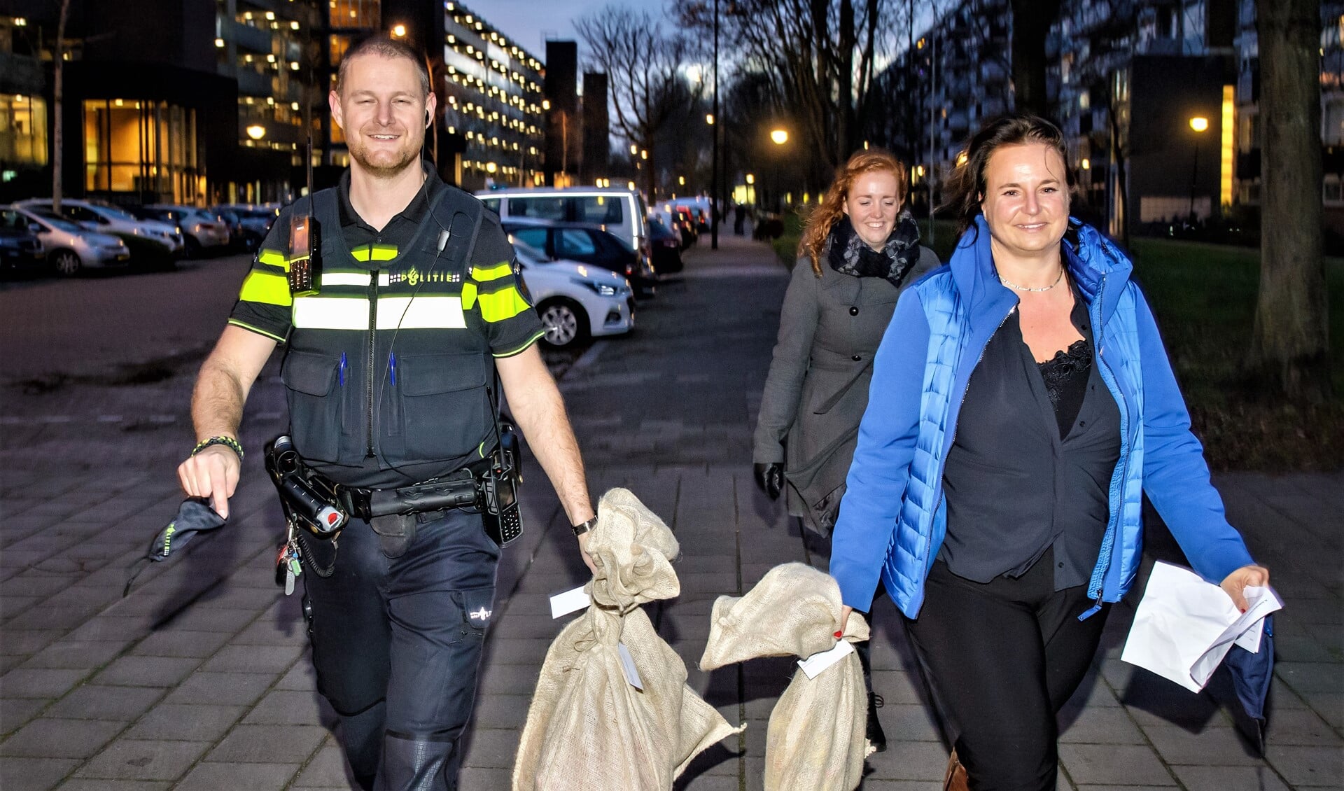 Onder andere wijkagent Robin Hoogervorst en wethouder Nadine Stemerdink hielpen bij de bezorging van de pakjes voor Sintvoorieder1 (foto: Paul Voorham).