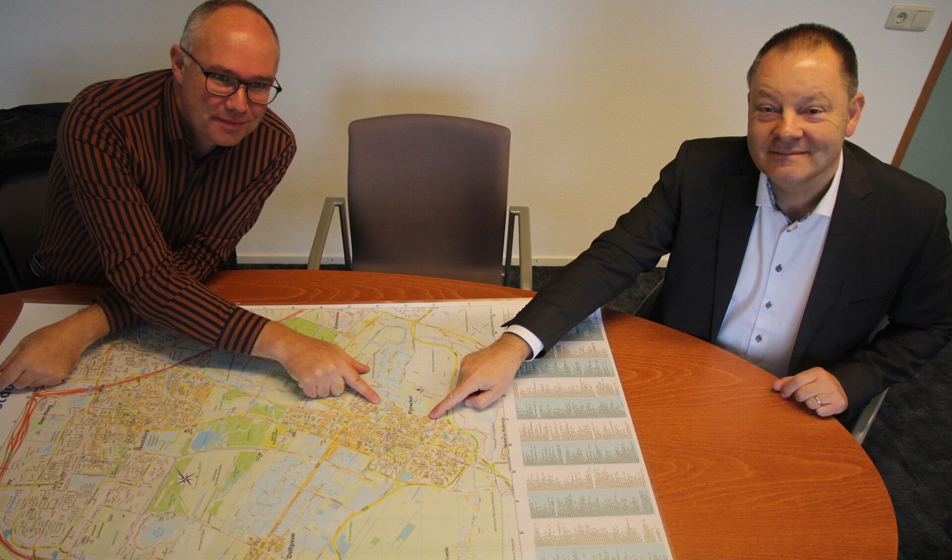 Projectleider Erik Bulten en wethouder Frank van Kuppeveld met de kaart van Pijnacker. Ze wijzen Klapwijk aan als een zeer geschikte wijk voor aardwarmte.