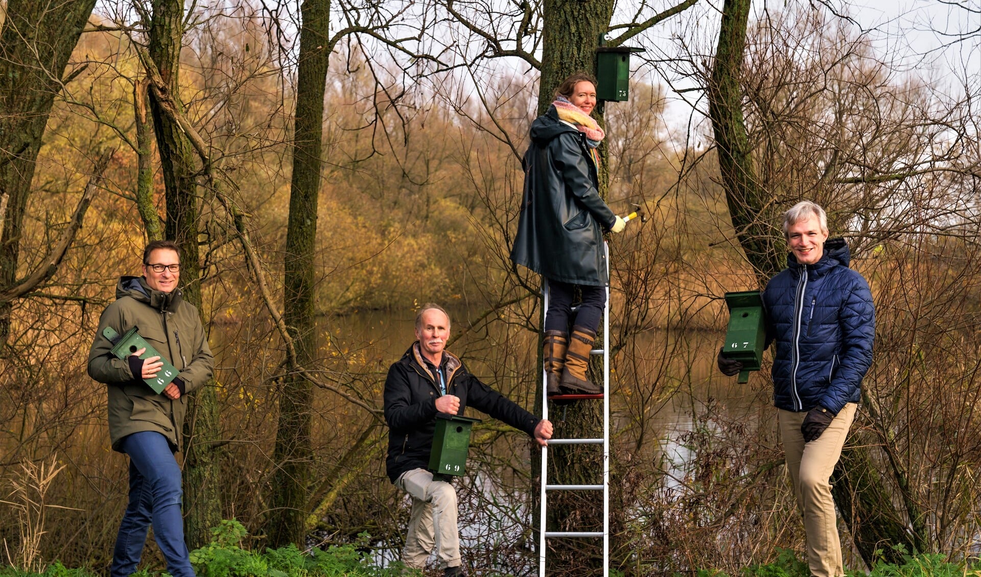 Ophangen van het 75e nestkastje in Vlietland: De twee gedeputeerden, Anne Koning ( op de ladder) en Berend Potjer ( r.), geflankeerd door de voorzitters van de Vogelwacht Delft (l.) en van de Vereniging Vrienden van Vlietland (foto: pr PZH).