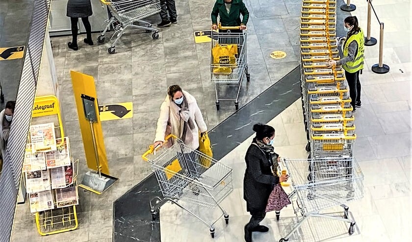 <p>Mondkapjes op, afstand houden en winkelwagentjes schoonmaken, een tijdsbeeld<br>bij een supermarkt in winkelcentrum Leidsenhage (foto: Michel Groen).</p>