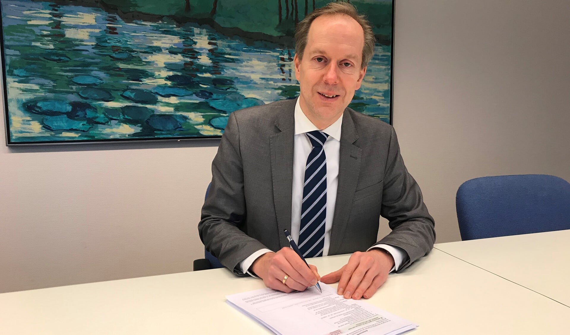 Wethouder Rouwendal tekent voor de verkoop van de aandelen, waarmee de gemeente zo'n 140 euro rijker wordt (foto: gemeente LDVB).