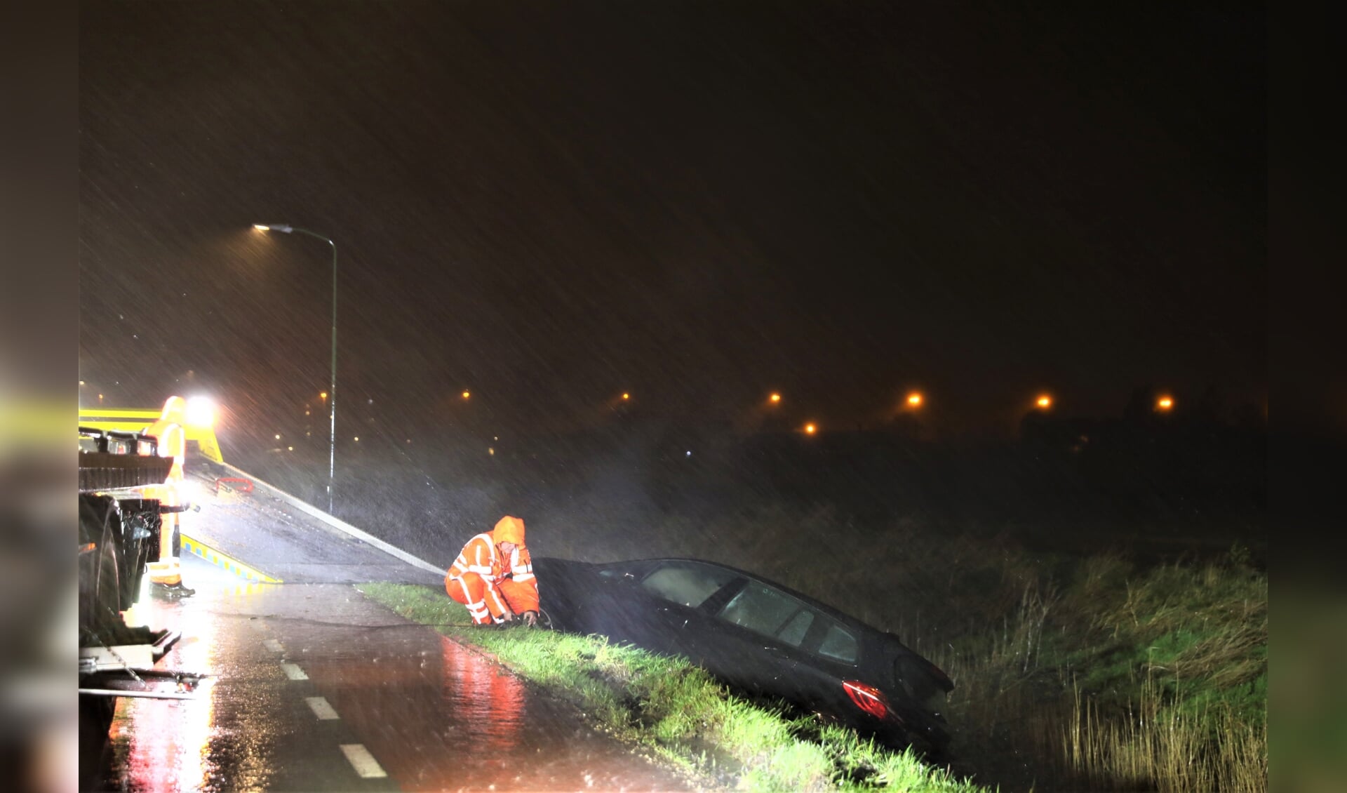 Tijdens het noodweer wordt de personenauto geborgen (foto: Sander Paardekooper).