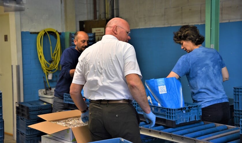 Burgemeester Tigelaar helpt bij het inpakken van de voedselpakketten bij de voedselbank aan de Fransstraat in Voorburg (foto: pr).