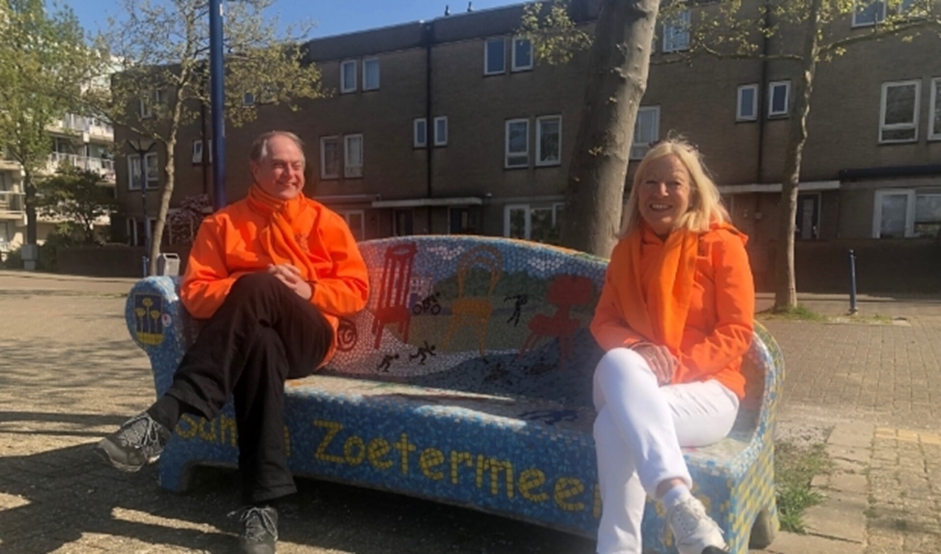 Wim Kokx geeft de voorzittershamer van de Oranjestichting Zoetermeer dit jaar door aan Marijke du Burck. Ze ontmoetten elkaar daags voor Koningsdag op dé 'Samen Zoetermeer' Sofa aan de Dobbeplas. Foto: SL