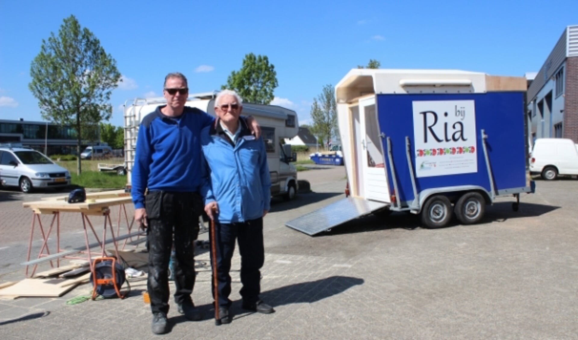 Aannemer René de Jong met zijn vader Jan de Jong, die onlangs zijn vrouw Ria verloor. Op de achtergrond de mobiele ontmoetingsruimte. (Foto: Martijn Mastenbroek)