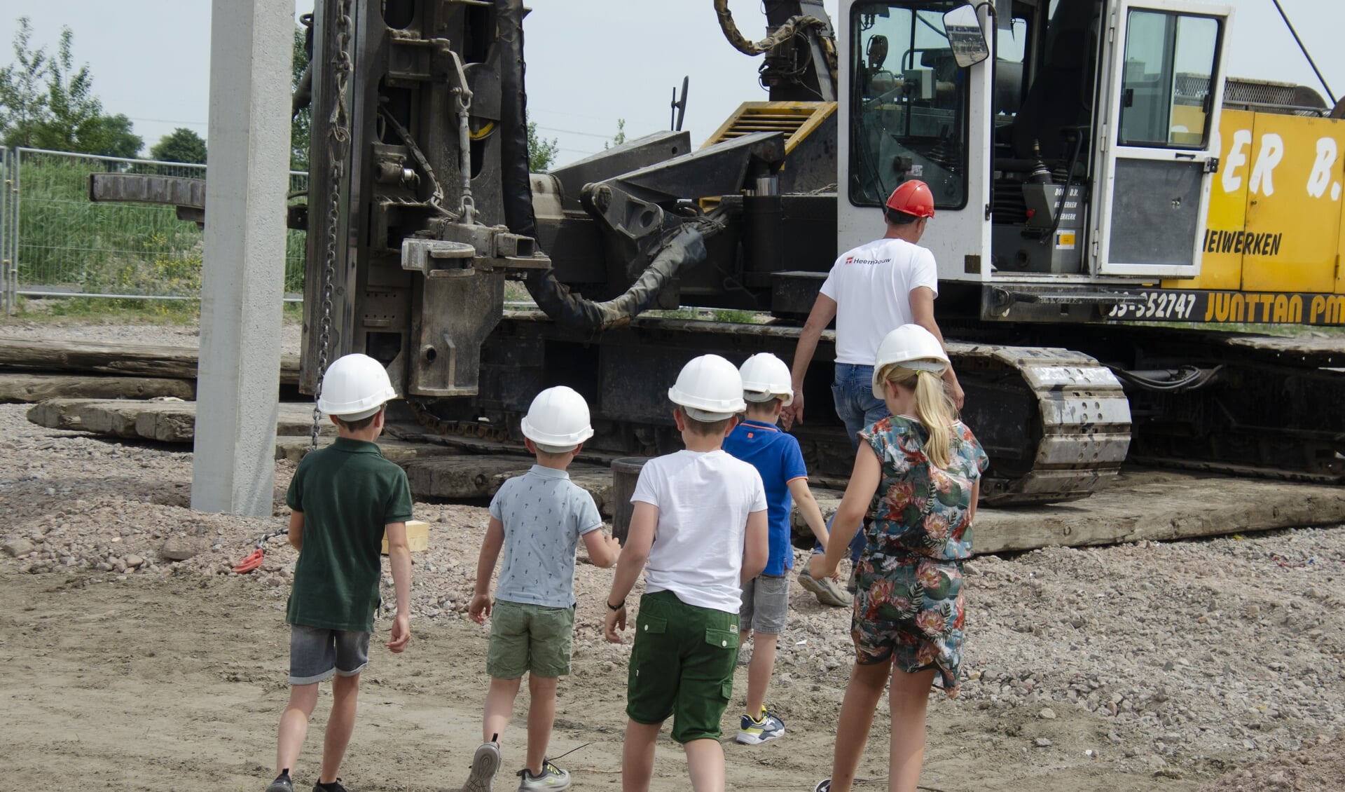 De kinderen van de eigenaren op weg naar hun ‘werk’: het slaan van de eerste paal. 