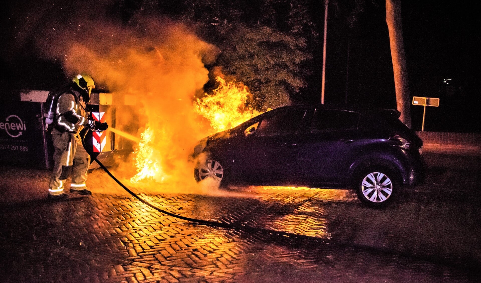 De brandweer blust de aan de voorzijde hevig brandende auto (foto: Sebastiaan Barel/Regio15).