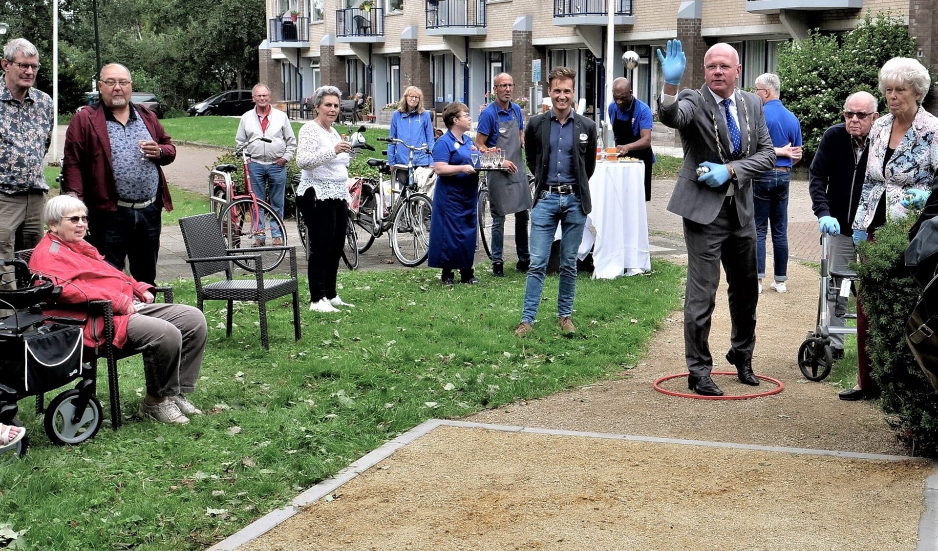 Burgemeester Klaas Tigelaar verricht de eerste worp op de nieuwe jeu-de-boulesbaan bij WZH Schoorwijck in Leidschendam (foto: Ot Douwes).