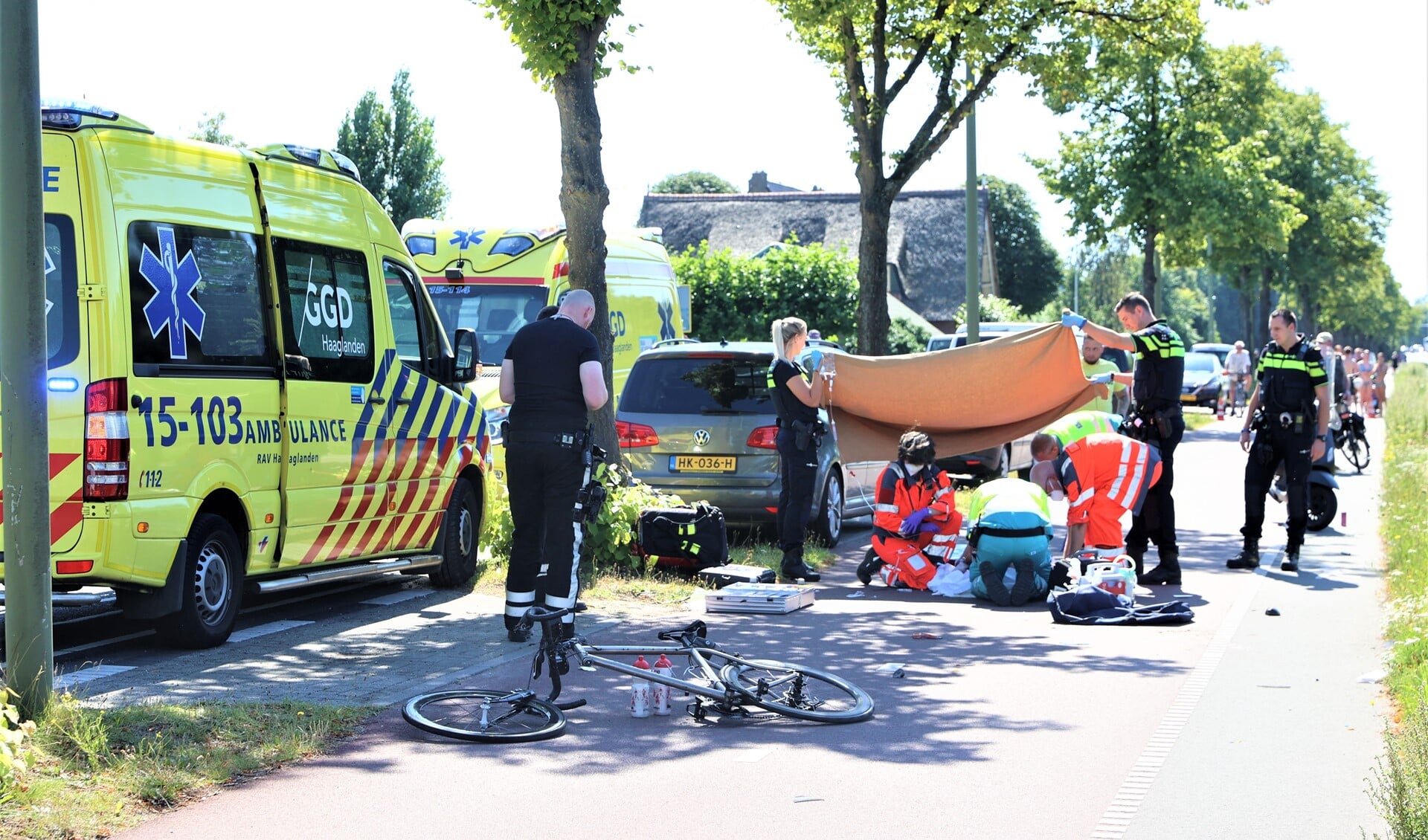 Ambulancepersoneel en medewerkers van het Mobiel Medisch Team verlenen hulp aan de zwaargewonde wielrenner (foto: Daan van den Ende).
