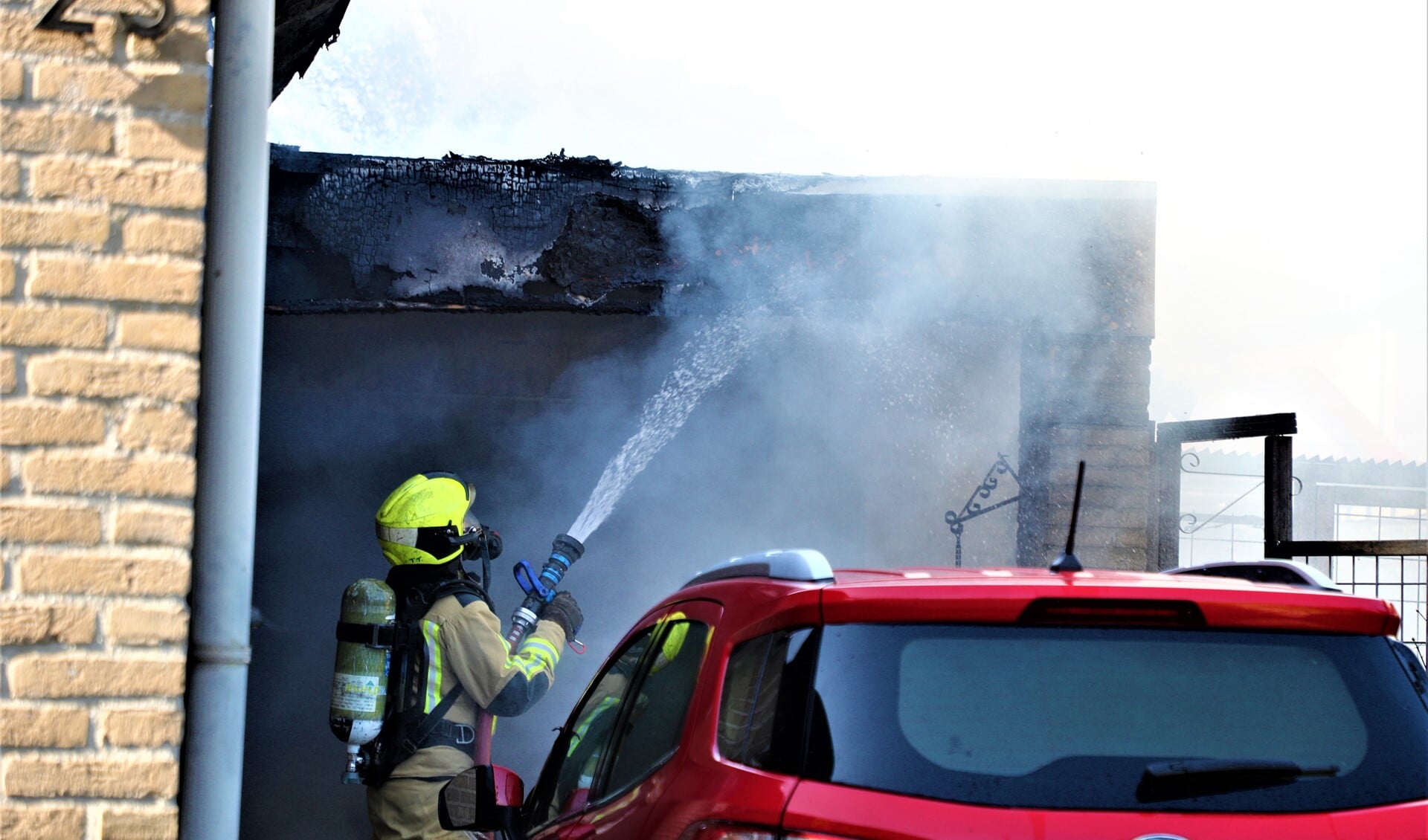 Het blussen van de brand in de garage aan de Wickelaan die ontstond door een elektrische oplader (foto: Rene Hendriks).