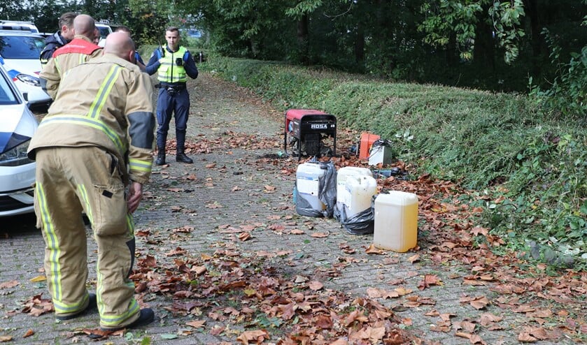 <p>De jaerrycans en andere spullen die werden aangetroffen an de rand van een parkeerplaats op Sportpark Westvliet (foto: Rene Hendriks).</p>