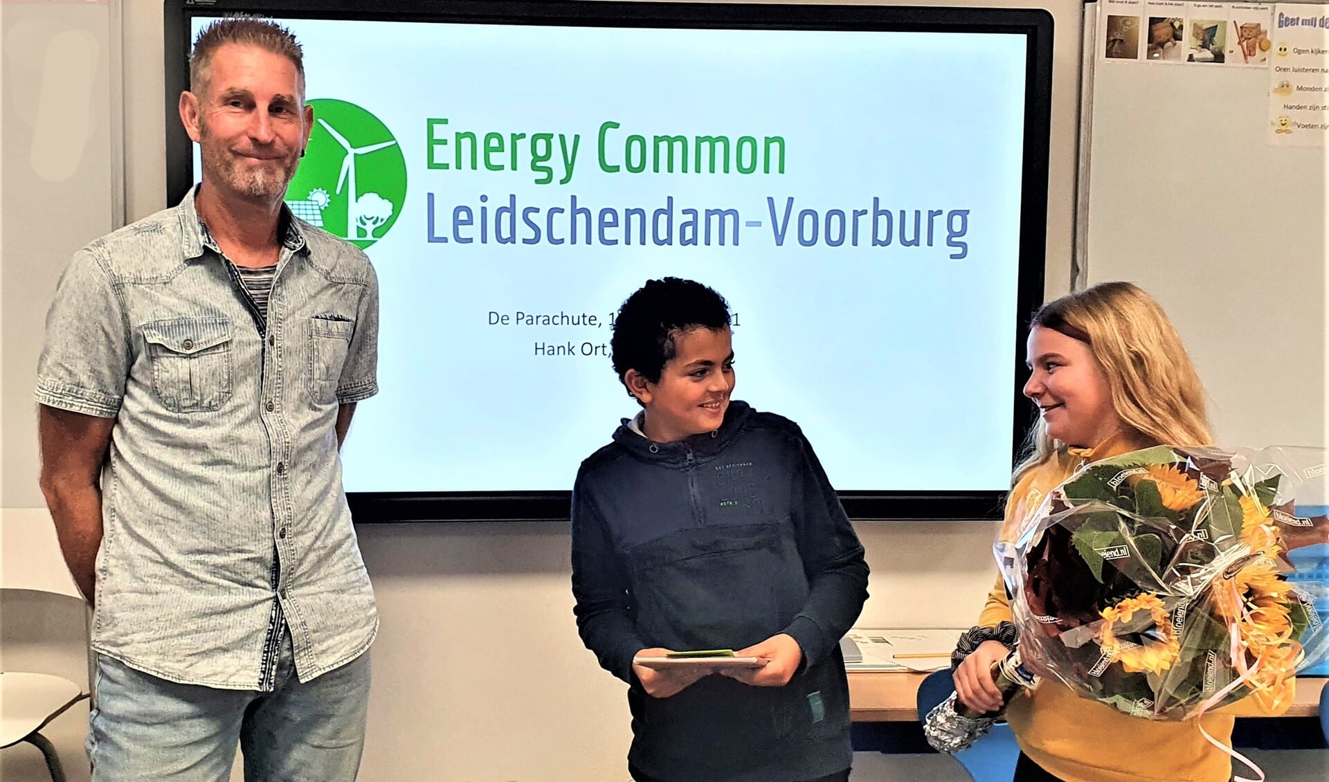 Uit handen van twee leerlingen ontving Ben Bleijs een bos zonnebloemen en het boek 'Mijn huis energiezuinig. Hoe pak je dat aan?' (pr).