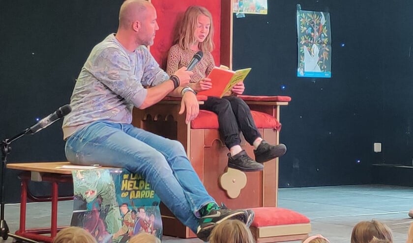 <p>Belize leest voor uit een boek vol humor.</p>
