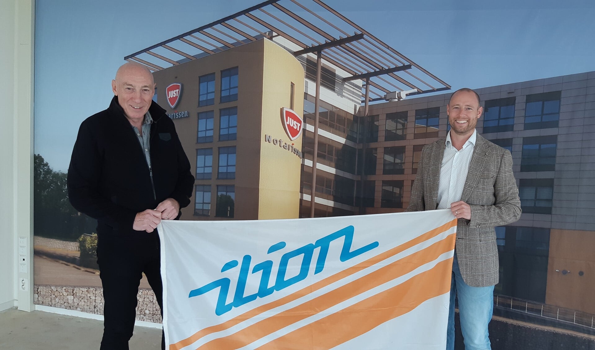 Camillus (l) en Lars Overmeire met Ilion vlag na ondertekening van de sponsorovereenkomst. (foto Ad Klok)