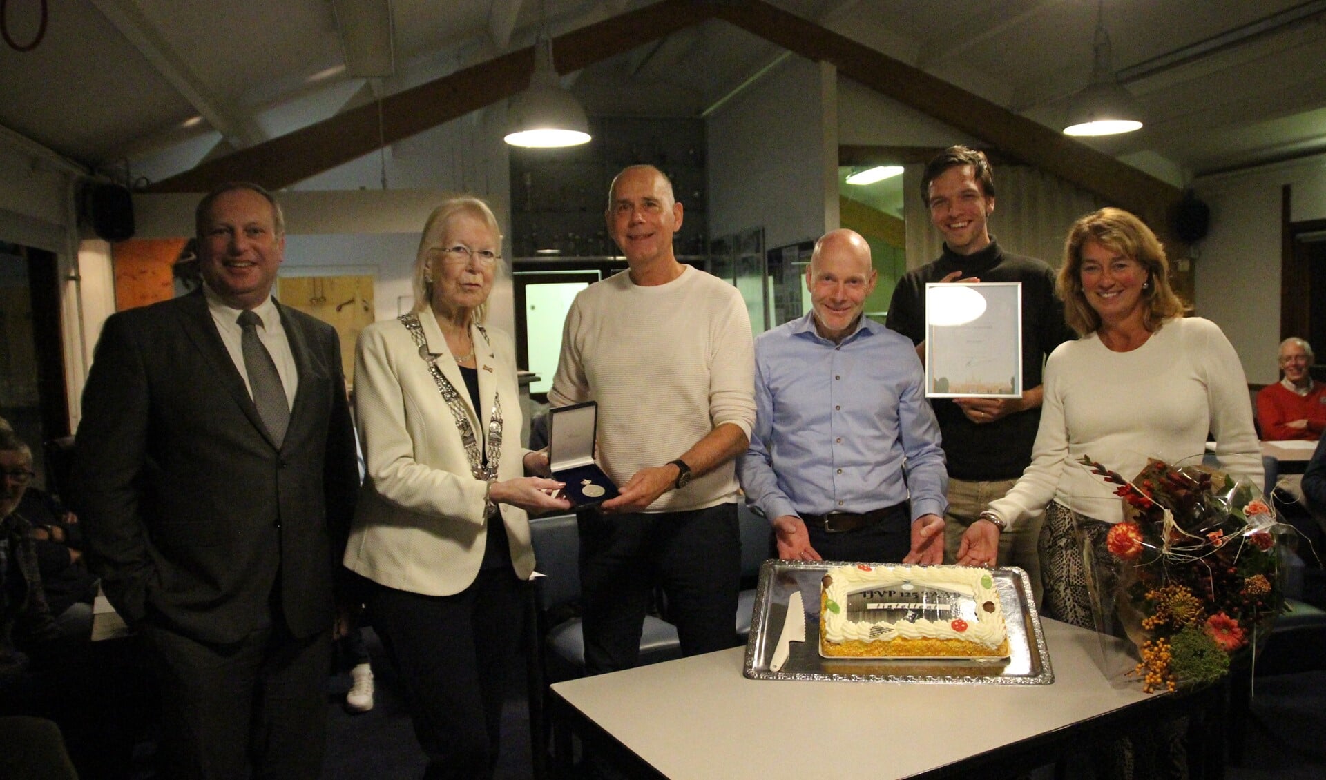 De burgemeester en de wethouder sport Peter Hennevanger op de foto met het trotse dagelijks bestuur van de IJVP. Er was voor de gelegenheid zelfs een taart gebakken.