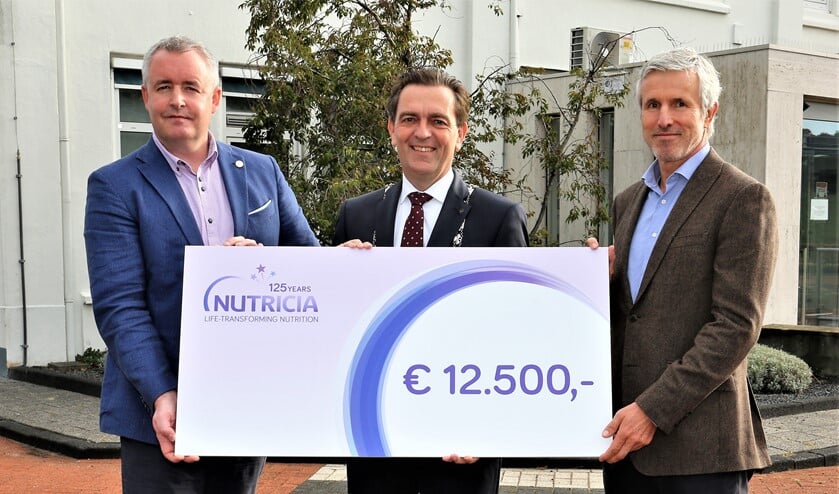 Burgemeester Bezuijen krijgt een cadeau van het jarige Nutricia. /Foto: Fred Roland