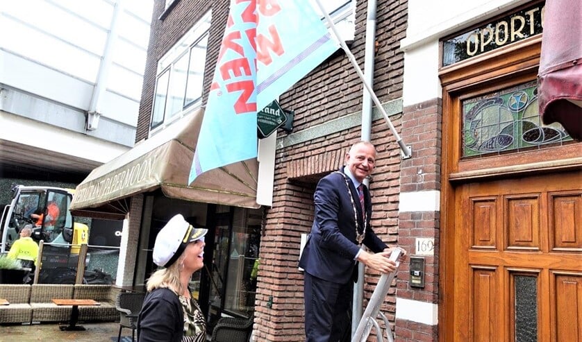 Burgemeester Jules Bijl hangt de vlag van de Kinderboekenweek op (foto: Ap de Heus).